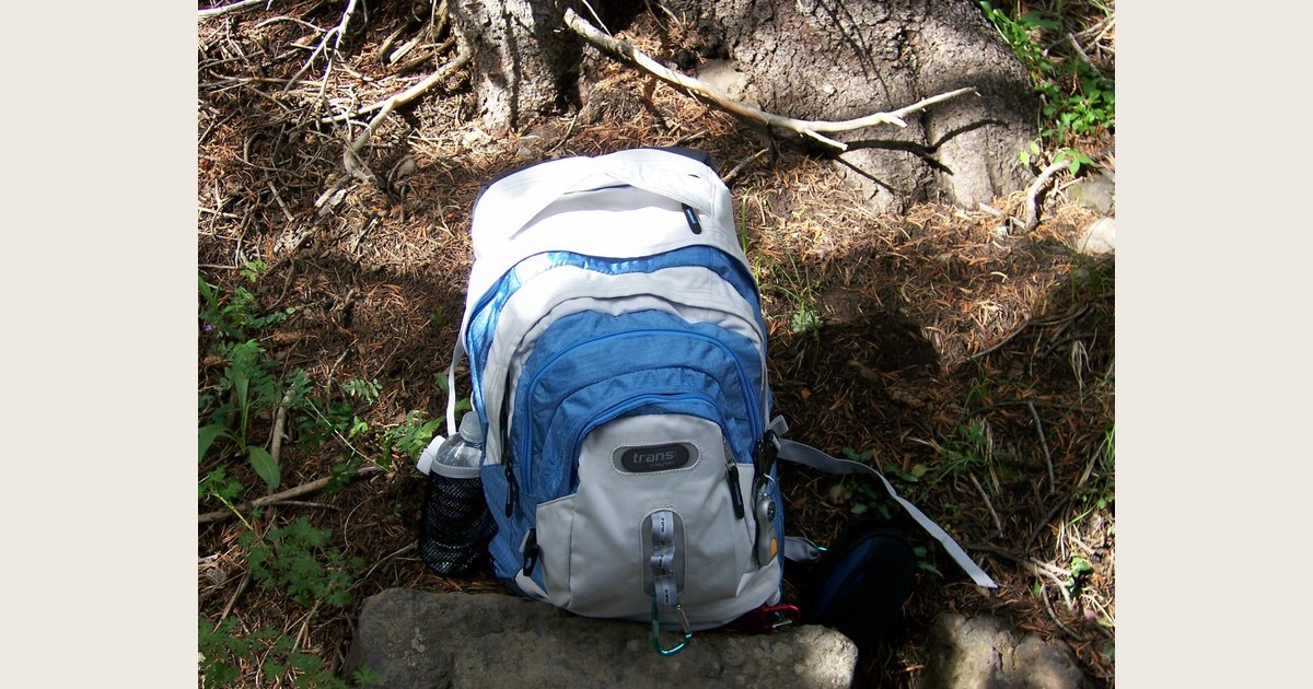 A hiking backpack resting on the ground outdoors