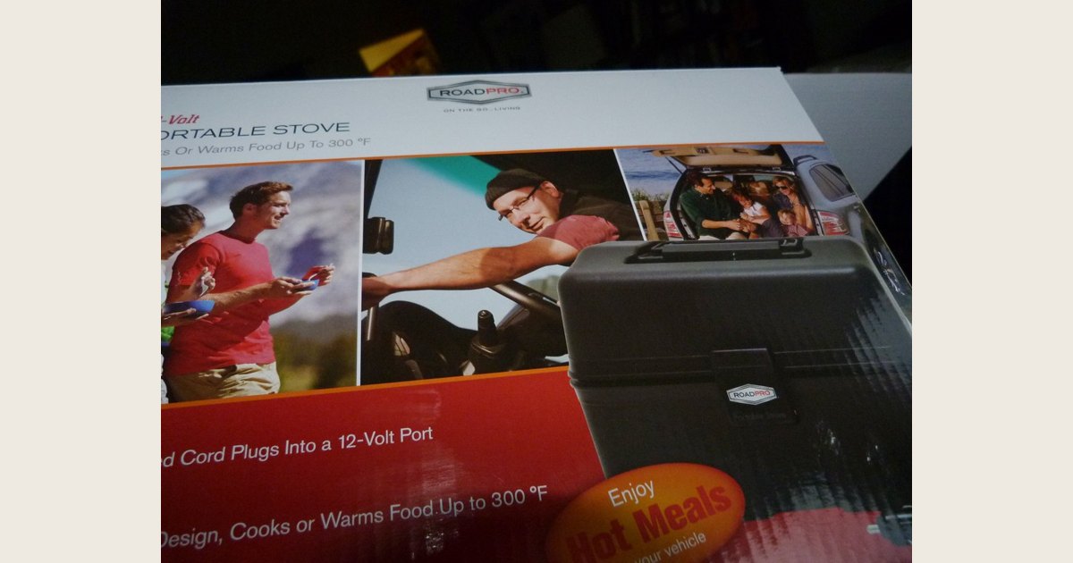 Packaging for a black RoadPro portable stove, with text stating that its cord plugs into a 12-volt port.